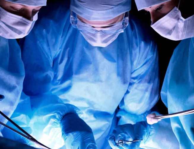 3 surgeons operating, dark background