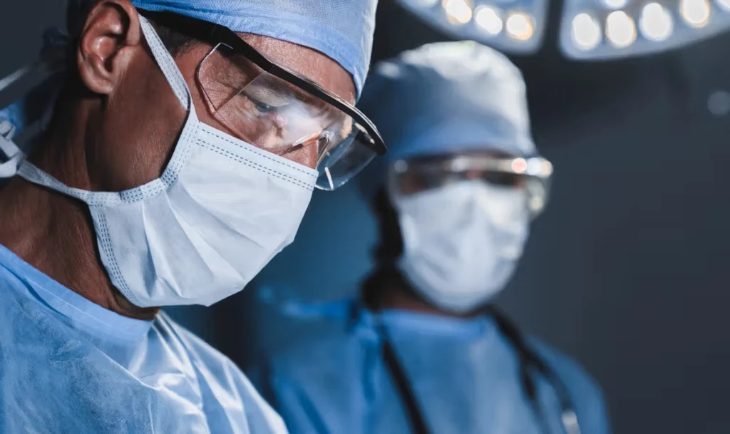Two surgeons looking down at patient