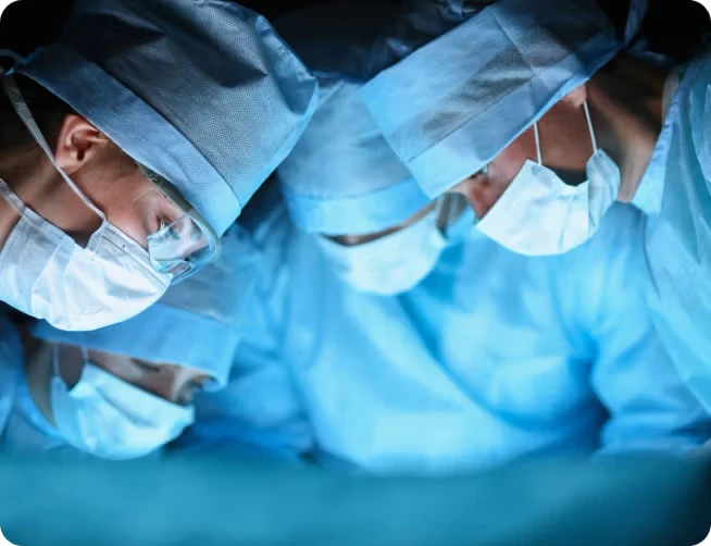 four surgeons looking down during surgery